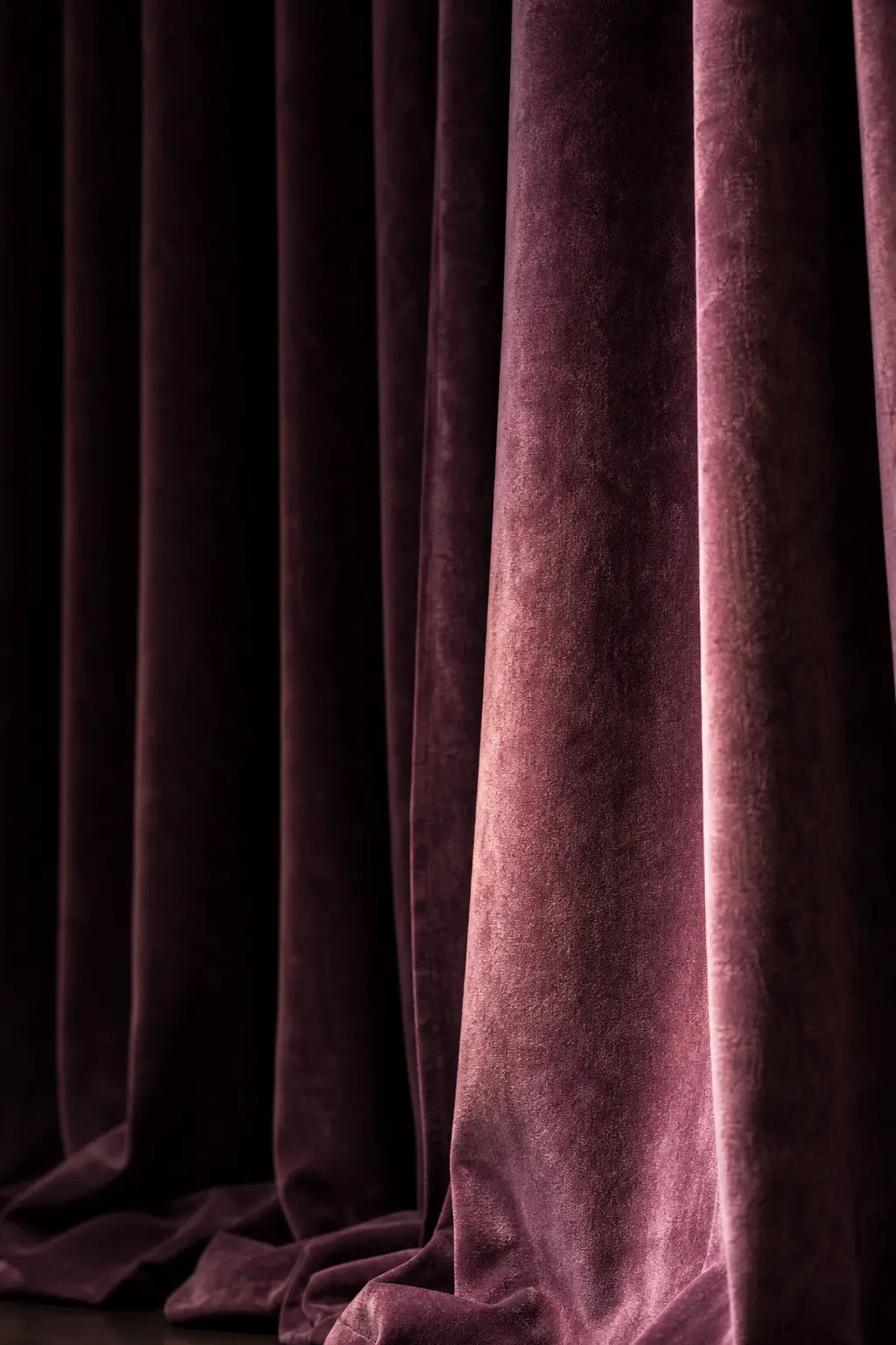 Heavy plum stage curtain falling in deep folds